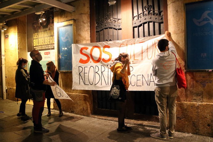 Pla general d'un grup de manifestants penjant una de les pancartes reivindicatives a les portes del Teatre Metropol de Tarragona en la protesta per reivindicar que la cultura és segura. Imatge del 31 d'octubre del 2020 (Horitzontal).