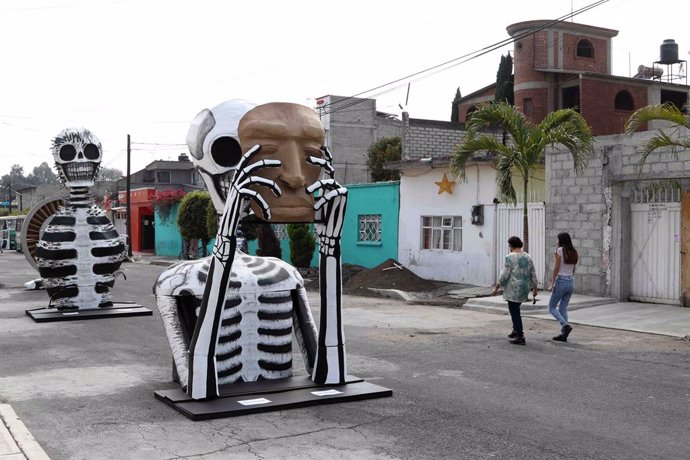 29 October 2020, Mexico, Mexico City: Passers-by walk near giant cardboard skulls at Francisco Santiago Borraz street which were placed for the Day of the Dead celebrations. Photo: -/El Universal via ZUMA Wire/dpa