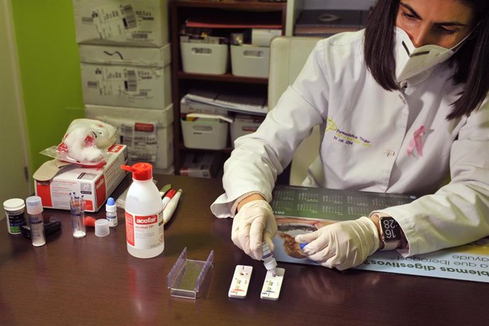 Una farmacéutica de la Farmacia Portal Martínez Soto añade el reactivo a una placa en la que ha introducido la muestra de sangre que ha tomado para realizar un test de cribado del coronavirus. En Barbadás (Orense), a 19 de octubre de 2020.