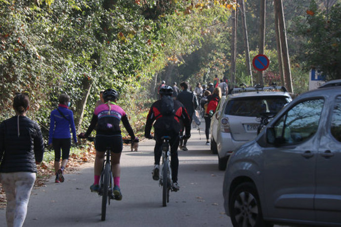 Pla mitj de l'inici d'uns dels camins que porta al Castell de Sant Miquel amb cotxes, bicis i gent caminant aquest diumenge 1 de novembre de 2020. (Horitzontal)