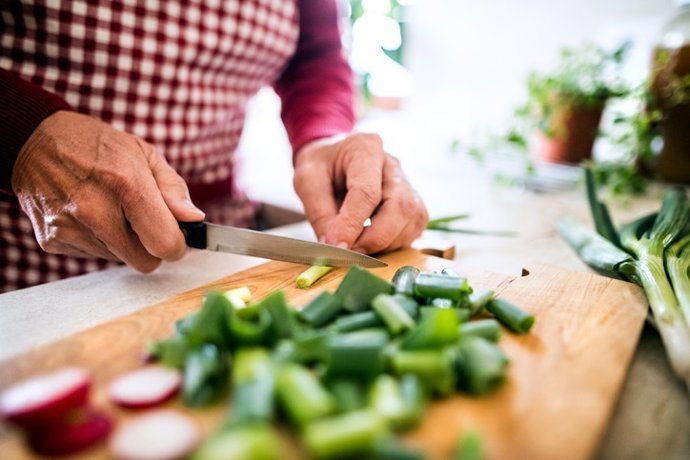 Hombre prepara comida en casa. Nutrición, dieta mediterranea.