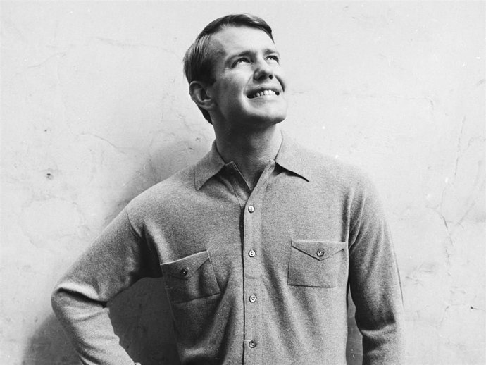 A square-jawed young man wearing a warm shirt with breast pockets by Gordon Lowe.