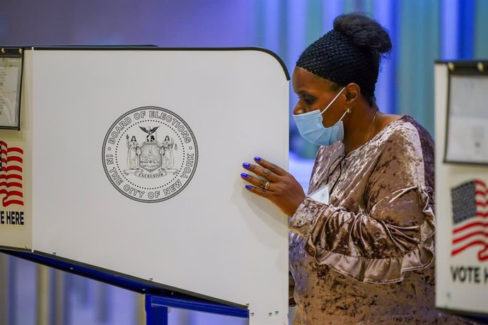 Una mujer con mascarilla vota en Nueva York.