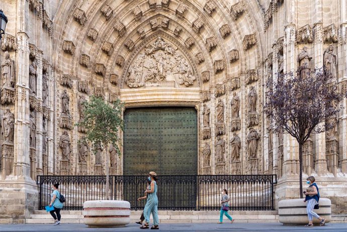 Paseantes por la puerta de la Anunciación de la Catedral de Sevilla 