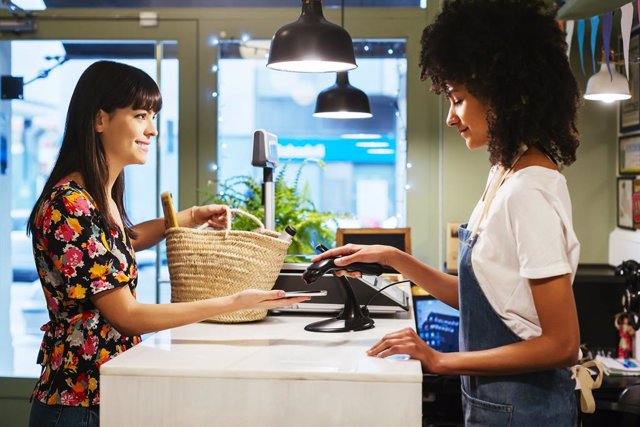 Cliente pagando con su smartphone en una tienda
