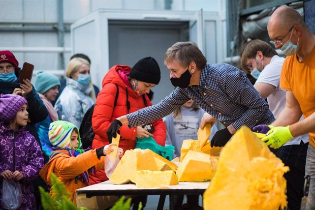 Empleados del jardín botánico repartiendo trozos de una calabaza gigante en Moscú