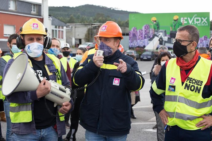 El presidente del comité de empresa de la planta de Alcoa en San Cibrao, José Antonio Zan (c), habla a través de un megáfono durante una nueva manifestación convocada por el Comité de Alcoa en la que cortan el tráfico en la carretera N-642 y el acceso a