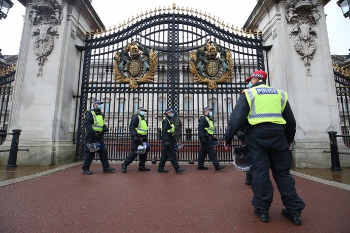 24 October 2020, England, London: Police officers with protective equipment gather at the gates of Buckingham Palace during a protest against the imposed lockdown restrictions to prevent the spread of coronavirus. Photo: Jonathan Brady/PA Wire/dpa