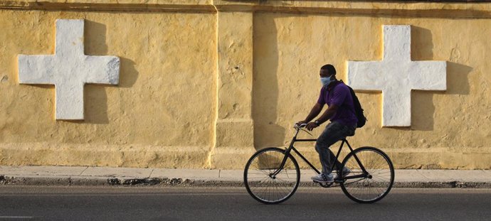30 August 2020, Cuba, Havana: A man rides his bicycle along the wall of Havana's Colon Cemetery, a curfew in Havana will be imposed from 1 to 15 September 2020 due to an increase in new coronavirus cases. Photo: Guillermo Nova/dpa