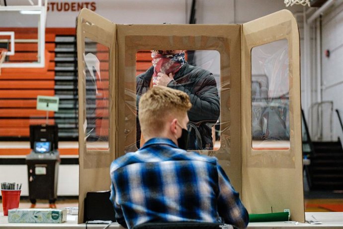 03 November 2020, US, Chagrin Falls: A man registers before casting his vote inside the Chagrin Falls High School polling station during the US Presidential election. Photo: Andrew Dolph/ZUMA Wire/dpa