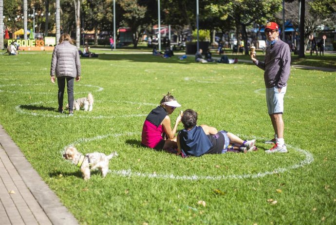 Un grupo de personas mantienen las distancias de seguridad marcadas en un parque de Bogotá, Colombia.