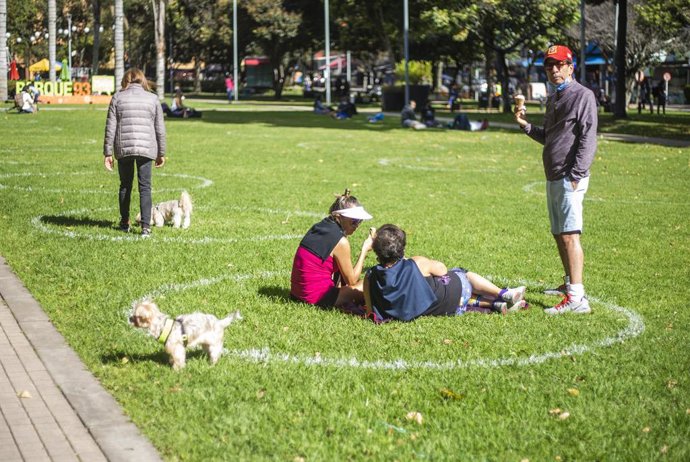 Un grupo de personas mantienen las distancias de seguridad marcadas en un parque de Bogotá, Colombia.