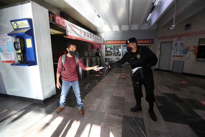 Un agente de la Policía repartiendo mascarillas en México.