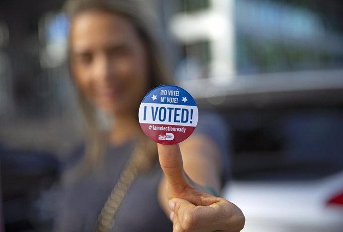 28 October 2020, US, Aventura: A woman poses for a picture with her vote sticker after casting her ballot during early voting for US Presidential election, 2020 at Northeast Dade - Aventura Branch Library. Photo: David Santiago/TNS via ZUMA Wire/dpa