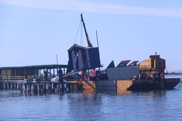 Pla general d'una grua aixecant la caseta dels lavabos del Xiringuito de la Costa, a la Punta de la Banya. Imatge del 29 d'octubre de 2020. (horitzontal)