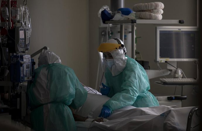 Dos sanitarios atienden a un paciente en la Unidad de Cuidados Intensivos (UCI) (Archivo)