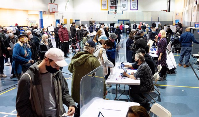 Electores estadounidenses votando con mascarilla por anticipado en Nueva York