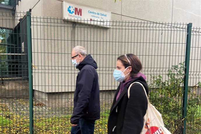 Dos personas pasna al lado de un centro de salud de Valdezarza, en el distrito de Moncloa-Aravaca, en Madrid (España), a 3 de noviembre de 2020. Valdezarza es una de las ZBS con restricciones de la Comunidad de Madrid. La Consejería de Salud de la regió