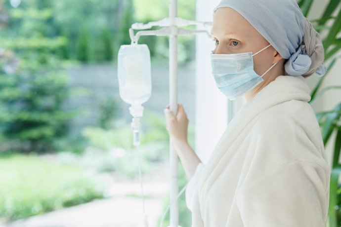 Mujer con cáncer en la ventana de un hospital.
