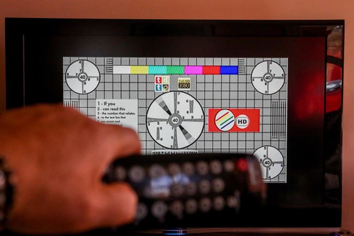 Una persona utiliza su mando de la televisión para buscar canales, en Madrid (España), a 7 de octubre de 2020. El cese de emisiones de algunos canales en sus antiguas frecuencias de la TDT en la Comunidad de Madrid se producirá este miércoles, según se 