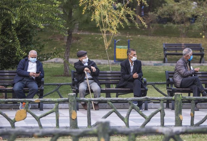 Hombres con mascarilla en un parque de Teherán