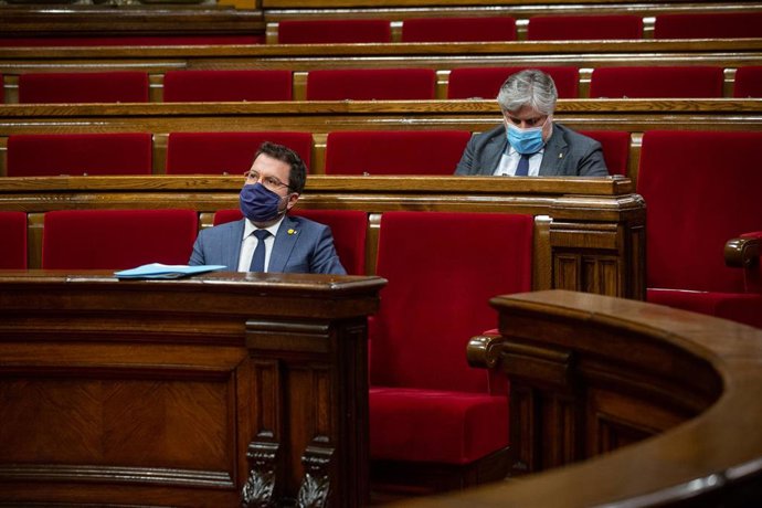 El presidente en funciones de la Generalitat, Pere Aragonés (delante), y el presidente de JxCat en el Parlament, Albert Batet, durante un pleno celebrado en el Parlament de Cataluña para tratar la crisis sanitaria del coronavirus, en Barcelona, Cataluny