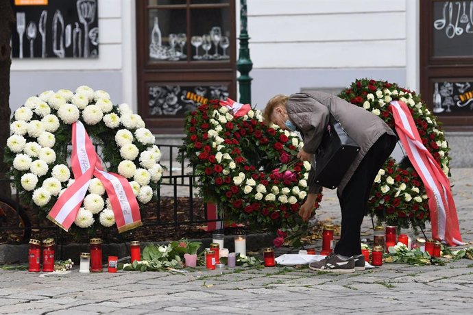 04 November 2020, Austria, Vienna: A woman lays flowers at a memorial site near the scene of the terror attack which happened on Monday evening that at least killed five people, including one perpetrator shot by police, though it remains unclear whether