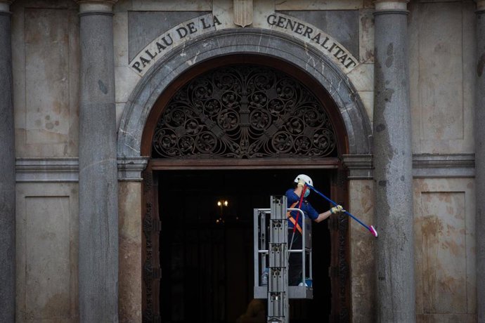 Una persona limpia una columna del Palau de la Generalitat una semana después de la entrada de las nuevas restricciones en Cataluña, en Barcelona, Catalunya(España) a 23 de octubre de 2020. 