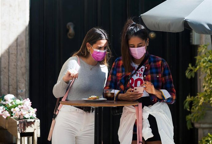 Consumidores de terrazas, bares y cafeterías con mascarillas