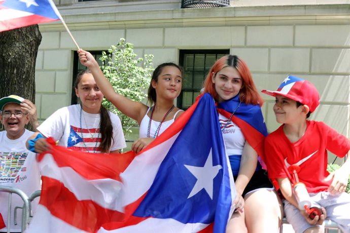 Varios jóvenes con la bandera de Puerto Rico.