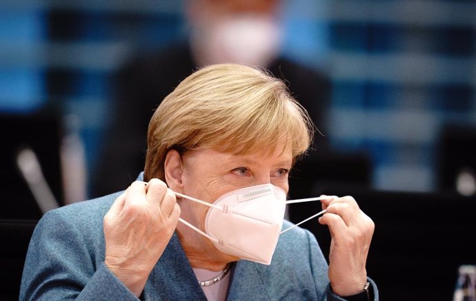 Angela Merkel quitándose la mascarilla tras llegar a una reunión en la Cancillería, en Berlín