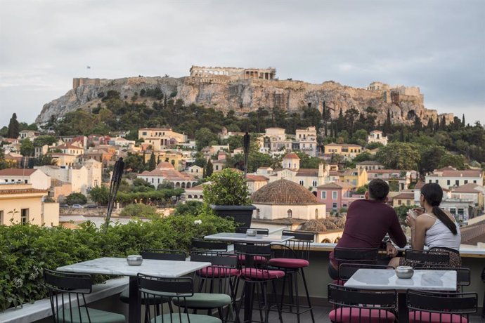 25 May 2020, Greece, Athens: Guests sit in a cafe in the Monastiraki district with the Acropolis in the background, as cafes and restaurants are allowed to reopen today after a lockdown due to the spread of the coronavirus pandemic. Photo: Socrates Balt