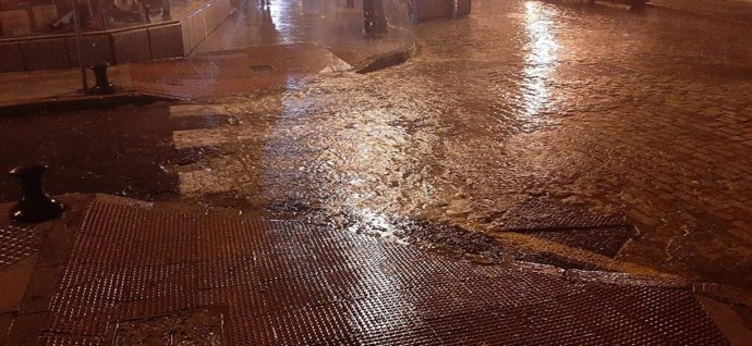 Una pequeña balsa de agua generada por la lluvia de este miércoles en una calle del centro de Huelva capital.