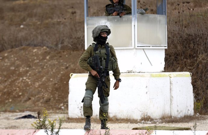 04 November 2020, Palestinian Territories, Nablus: An Israeli soldier stands guard near an area where a Palestinian gunman opened fire at a military post and troops returned fire to kill him at the Huwara checkpoint south of the West Bank city of Nablus