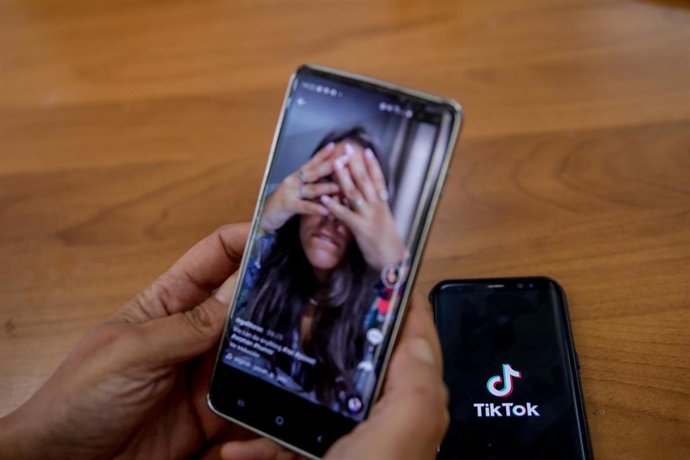 Una persona mira en su móvil el vídeo de una joven en la red musical Tik Tok, en Madrid (España).