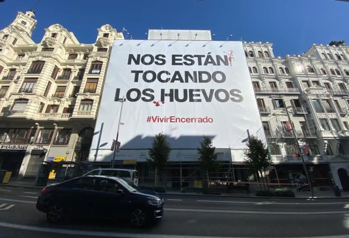 Igualdad Animal despliega una lona en Gran Vía para denunciar el encierro en jaulas de las gallinas ponedoras.