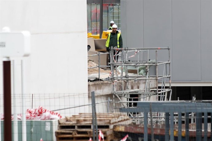 Varios obreros trabajan con maquinaria de construcción en las obras del nuevo Hospital de Emergencias de la Comunidad de Madrid