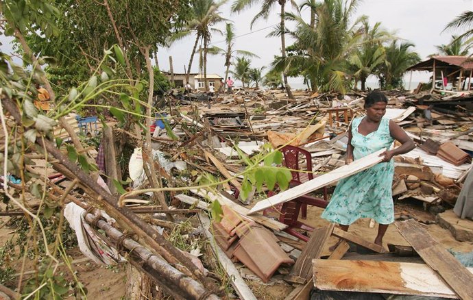 Una mujer recoge restos de los daños materiales en Sri Lanka provocados por el tsunami que azotó en 2004 a países del Océano Índico.