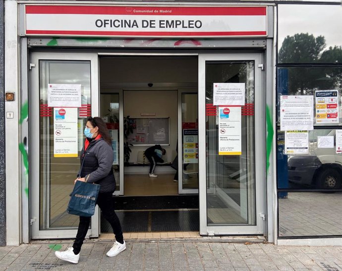 Una mujer sale de una oficina de empleo