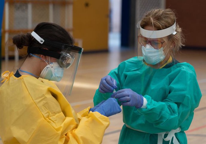 Sanitarios trabajando durante las pruebas de cribado de covid-19 con test de antígenos en el pabellón deportivo de 'El Paraguas'. En Sevilla (Andalucía, España), a 28 de octubre de 2020.