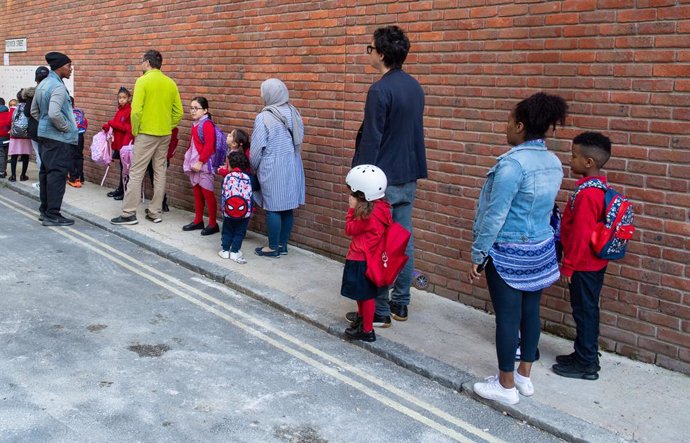 01 September 2020, England, London: Parents queue up with their children at Charles Dickens Primary School on the first day of reopening schools after closure due to coronavirus pandemic. Photo: Dominic Lipinski/PA Wire/dpa
