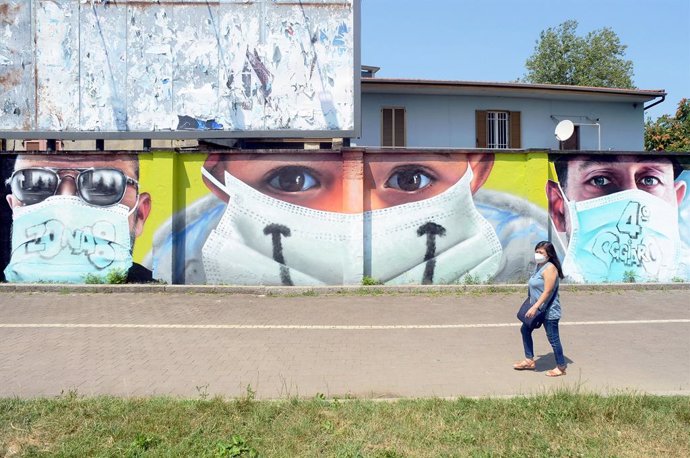 Un mural de personas con mascarillas en Milán