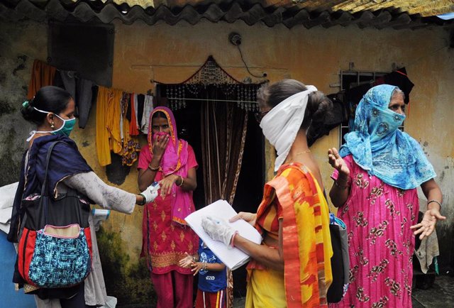Una sanitaria comprueba los niveles de oxígeno de una mujer en India durante la crisis sanitaria provocada por la COVID-19.