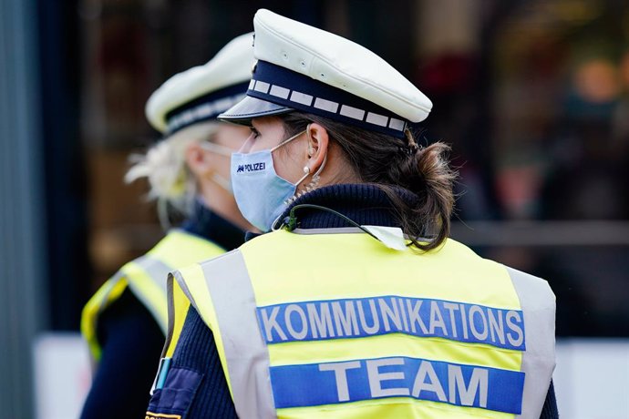 02 November 2020, Baden-Wuerttemberg, Heidelberg: Two police officers of a communication team stand at the Bismarckplatz Park during a check of the new Coronavirus rules. Federal and state governments have decided on a partial lockdown starting from tod
