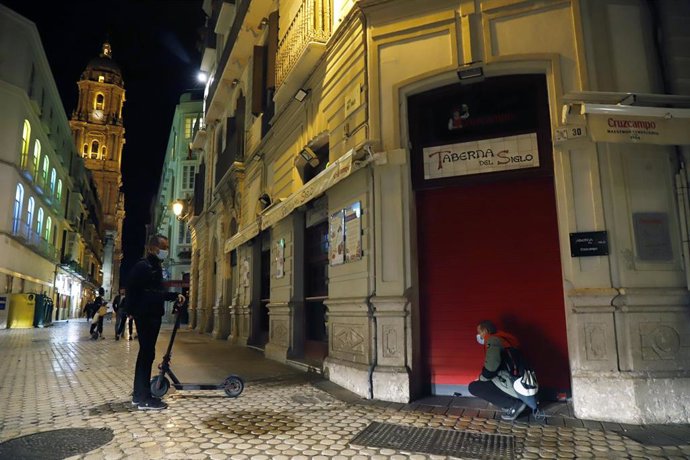 Un camarero cierra el bar  ubicado en el centro de la capital, como  consecuencia del toque de queda impuesto por el Gobierno para poder frenar el contagio en Málaga a 27 de octubre 2020