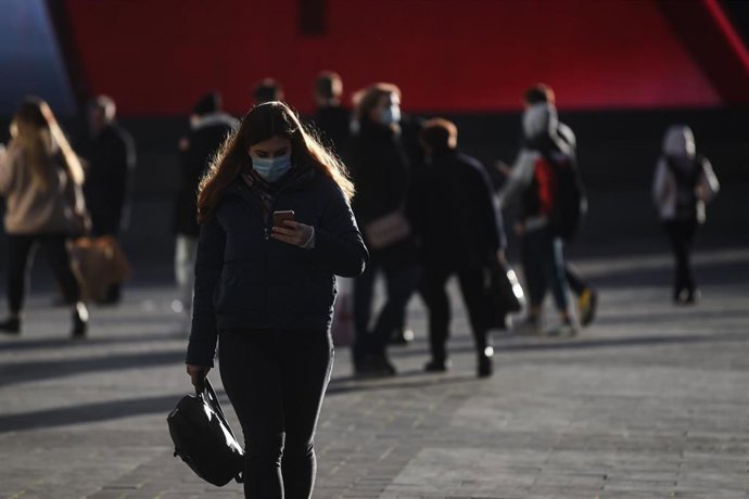 Una mujer con mascarilla pasea por Moscú