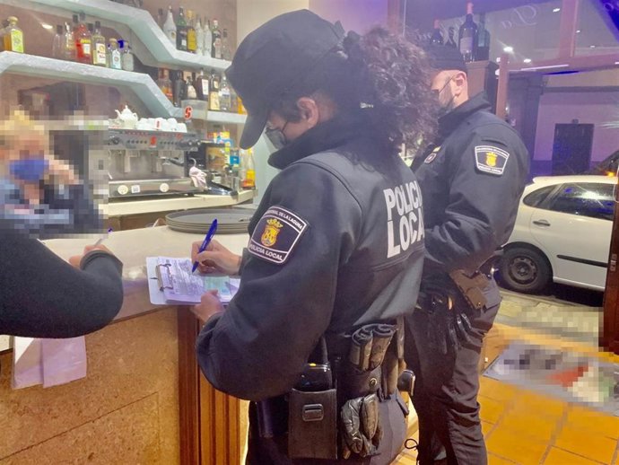 Una agente de la Policía Local de La Laguna levanta un acta de propusta de sanción en un bar
