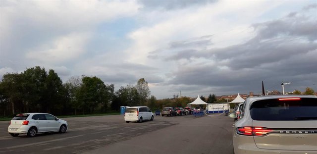 Carpa de Transinsa en la que se ha instalado un Autocovid en Gijón, con coches esperando a la realización de las PCR.
