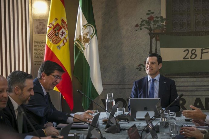 El presidente de la Junta de Andalucía, Juanma Moreno (d), preside la reunión del Consejo de Gobierno 