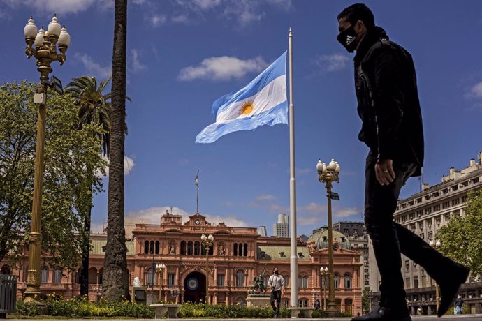 Un hombre con mascarilla camina frente a la Casa Rosada en Buenos Aires en plena crisis sanitaria.
